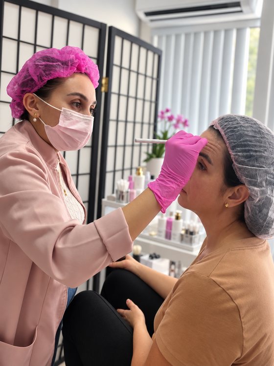 Dra. Jéssica Alencar avaliando o rosto de uma cliente